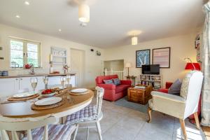 a kitchen and living room with a table and chairs at Folly Cottage in East Dean