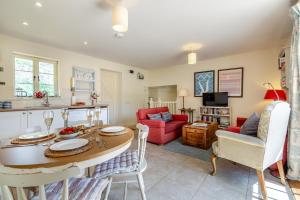 a kitchen and living room with a table and chairs at Folly Cottage in Eastdean