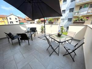 a patio with a table and chairs and an umbrella at Only Time- Luxury Comfort House in Chivasso +34 photos