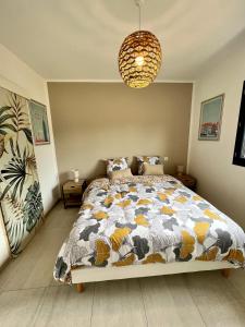 a bedroom with a bed and a chandelier at Casa Lamaghjone - Villa T4 avec piscine chauffée à 3,5km de la mer in Aléria +60 photos