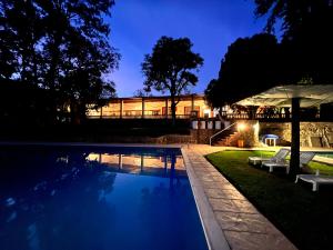 a house with a swimming pool at night at Lourdes Hotel Campestre in Tierranueva