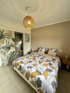 a bedroom with a large bed and a chandelier at Casa Lamaghjone - Villa T4 avec piscine chauffée à 3,5km de la mer in Aléria