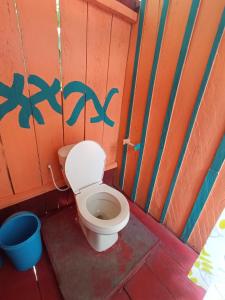a bathroom with a toilet and a bucket at Hostal Búho Amazonas tours in Leticia