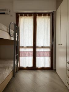 een slaapkamer met een stapelbed en een raam bij Appartamento Sole Blu in Alghero