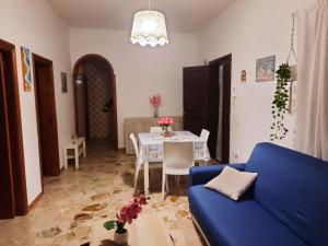 Villa Romana في Leporano Marina: غرفة معيشة مع أريكة زرقاء وطاولة