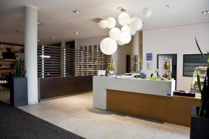 a lobby with a reception counter and lights at business & conference Sporthotel Großwallstadt in Großwallstadt