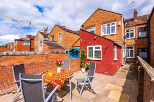 a patio with a table and chairs and a red house at Harley House in Parkside