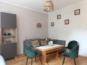 - un salon avec un canapé, une table et des chaises dans l'établissement Apartament Baltica Nawigator, à Gdynia