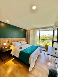 1 dormitorio con 1 cama grande y pared verde en Hotel Lagoon en Rionegro