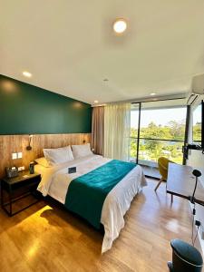 a bedroom with a large bed with a green wall at Hotel Lagoon in Rionegro