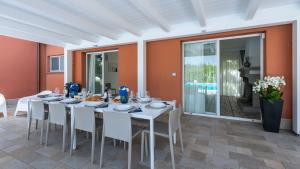 une salle à manger avec une table blanche et des chaises blanches dans l'établissement VILLA NINETTA 10&1, Emma Villas, à Giulianova