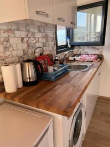 a kitchen counter with a sink and a washing machine at Orman ile iç içe ağaç ev in Ula