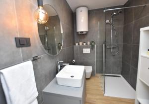 a bathroom with a sink and a shower and a mirror at Apartment Palcic in Primošten +24 photos
