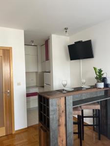 a kitchen with a table with two wine glasses on it at Studio Pao in Podgorica +8 photos