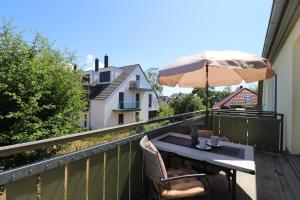a table and chairs on a balcony with an umbrella at Altes Wasserwerk App 20 in Wustrow