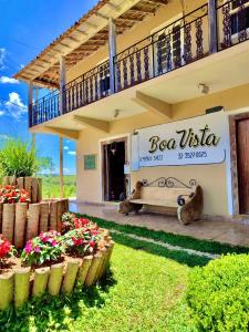 un edificio con un banco en un patio con flores en Pousada Boa Vista, en Tiradentes