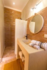 Villa Essaouira petit déjeuner compris في الصويرة: حمام مع حوض ومرآة