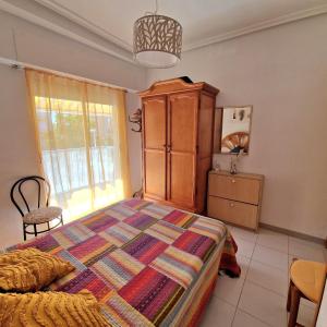 ein Schlafzimmer mit einem Bett, einer Kommode und einem Fenster in der Unterkunft Sol Apartment in Arenales del Sol