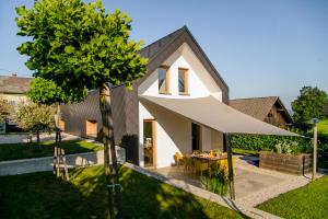 une maison avec un grand auvent blanc dans une cour dans l'établissement Modern house T&D for 7 pax with spacious garden, à Zgornje Gorje