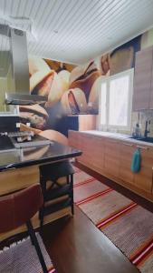 a kitchen with a table and a wall with a mural at Villa Vihreä Yyteri in Pori