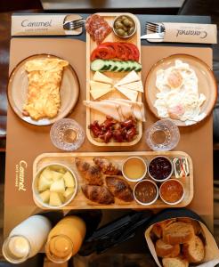 a table filled with different types of food at Caramel Boutique Hotel in Gjirokastër