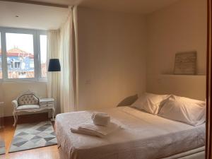 um quarto com uma cama, uma cadeira e uma janela em Gago Coutinho Apartment em São Jacinto
