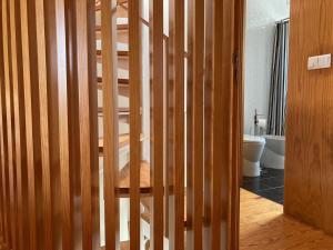 uma escada de madeira numa casa de banho com WC em Gago Coutinho Apartment em São Jacinto