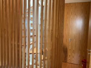 uma escada de madeira num quarto com uma parede de madeira em Gago Coutinho Apartment em São Jacinto
