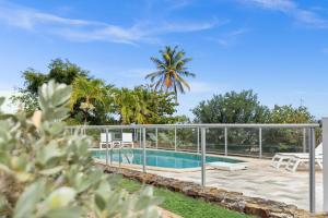 a villa with a swimming pool and palm trees at Esmeralda Resort in Orient Bay