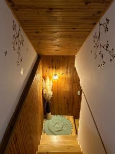 a small room with a wooden staircase with a vase of flowers at Gîte Chez Pierrot in Vivario