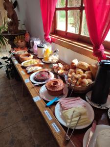 una mesa llena de diferentes tipos de pan y repostería en Pousada Boa Vista, en Tiradentes