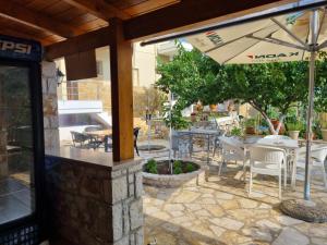 a patio with an umbrella and tables and chairs at Foti Rooms in Himare