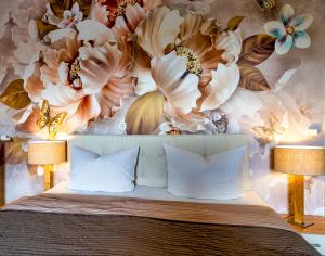 a bedroom with a mural of flowers on the wall at Akzent Hotel Alte Direktionsvilla Kupfermühle in Flensburg