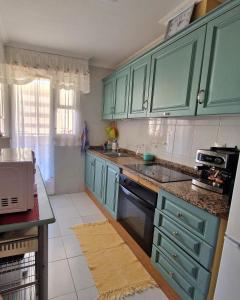 eine Küche mit blauen Schränken und einer Arbeitsplatte in der Unterkunft Sol Apartment in Arenales del Sol