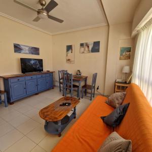 ein Wohnzimmer mit einem Sofa und einem Tisch in der Unterkunft Sol Apartment in Arenales del Sol