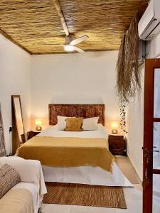 a bedroom with a large bed with a wooden headboard at Arcos de Tarifa, Casco historico in Tarifa