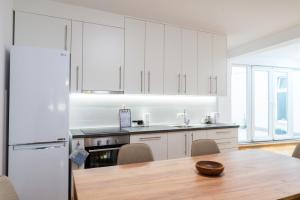 a kitchen with white cabinets and a wooden table at Alma apartments in Mostar