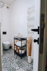 Apartament Loft nad Rzeką 3 pokojowy في أوسترون: حمام مع أرضية بلاط سوداء وبيضاء