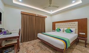 a bedroom with a bed and a desk in a room at Treebo Aaravi Residency, 800 Mtrs From Promenade Beach in Puducherry