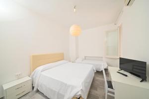 a bedroom with two beds and a desk and a tv at Villa Diana - Beach & Rooms in Ischia