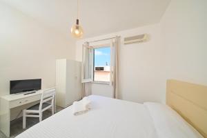 a bedroom with a bed and a desk and a television at Villa Diana - Beach & Rooms in Ischia