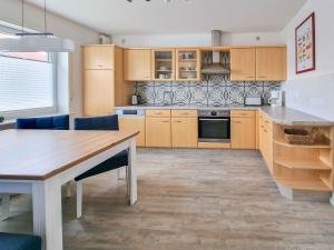 a kitchen with wooden cabinets and a wooden table at Küstenschwalbe in Greetsiel