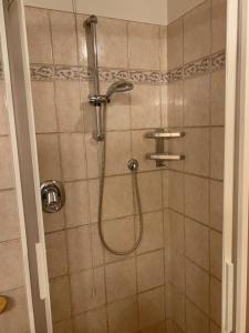 y baño con ducha y manguera. en Appartamento Genziana, en Predazzo
