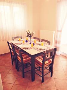 a dining room table with chairs and a table with flowers at Villa Aspro in Xirostérnion