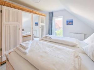 1 dormitorio blanco con 2 camas y ventana en Küstenschwalbe, en Greetsiel