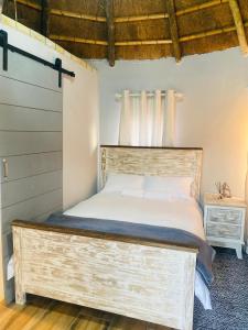 Schlafzimmer mit einem Bett mit einem Kopfteil aus Holz in der Unterkunft Seqonoka Villa Accommodation & Events Park in Berea Hills