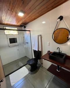 a bathroom with a shower and a toilet and a sink at Pousada Rosa dos Ventos Kchu in Cachoeiras de Macacu