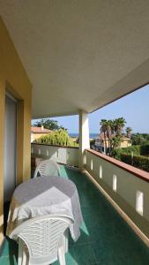 a balcony with a table and chairs and the ocean at Sea's Chalet in Fontane Bianche