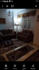 a living room with two couches and a rug at Gibran residence in Kafr al Ishārah