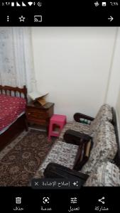 a picture of a bedroom with a bed and a pink stool at Gibran residence in Kafr al Ishārah